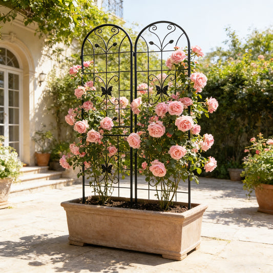 Black metal garden trellis with butterfly motif inserted into a garden container planter