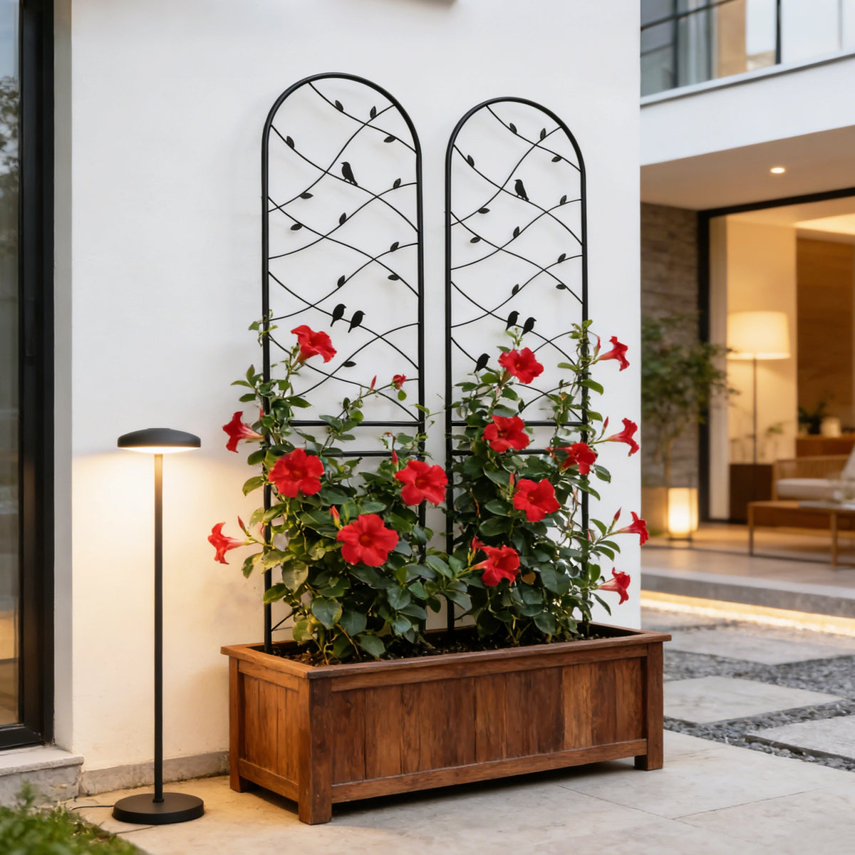 Decorative bird and vine metal trellis installed inside a wooden raised garden bed for climbing herbs