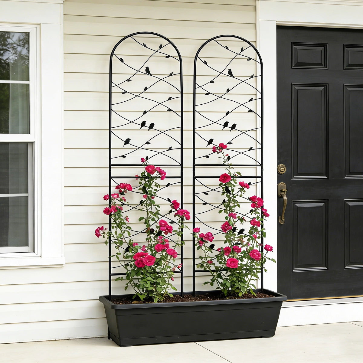Pair of decorative bird design metal trellises set together on one side of a front porch entrance