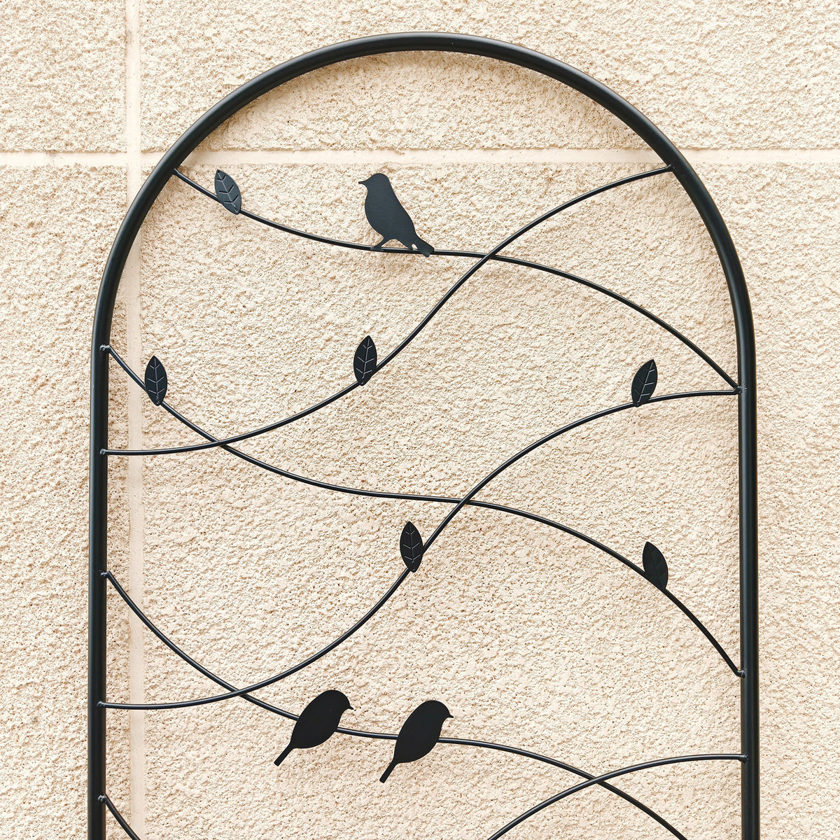 Close-up of decorative metal bird and leaf vine details on a rustproof black plant trellis
