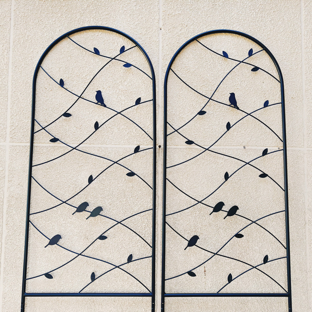 Close-up of decorative metal bird and leaf vine details on a rustproof black plant trellis